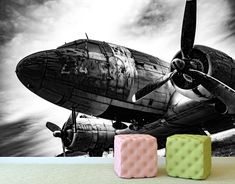 two cubes sitting on the floor in front of an old airplane wallpaper mural