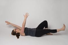 a woman is laying on the floor with her arms up in the air and legs spread out