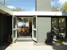 an open door leading to a patio with chairs and table in the back yard area