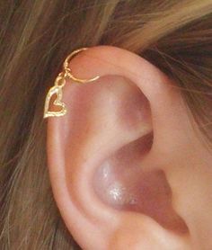 a close up of a person's ear with a gold chain attached to it