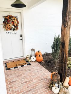 pumpkins and gourds are sitting on the front porch for fall decorating