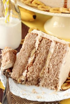 a piece of cake on a plate with a fork and glass of milk next to it