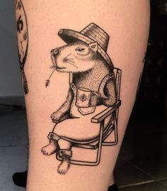 a black and white photo of a rat sitting in a chair with a hat on it's head