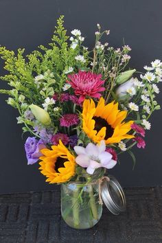 a vase filled with lots of different colored flowers