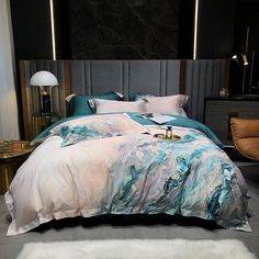 a bed with blue and white comforter next to a night stand in a room