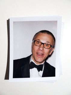 an old photo of a man in a tuxedo wearing glasses and a bow tie