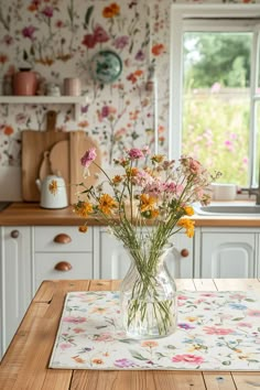 a vase filled with flowers sitting on top of a wooden table next to a window