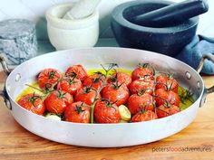 a pan filled with tomatoes on top of a wooden table