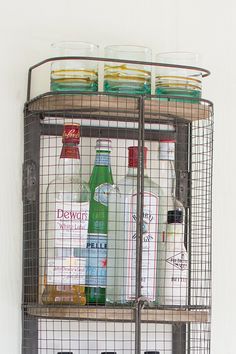 a metal shelf with bottles and glasses on it