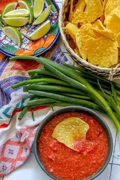 green beans, onions and tortilla chips on a table next to a bowl of guacamole