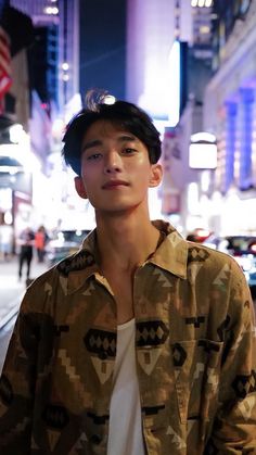 a young man standing in the middle of a city at night with his eyes closed