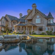 a large house with a pond in front of it