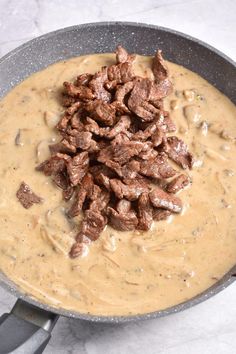 meat and gravy in a skillet ready to be cooked