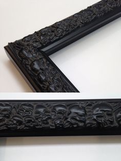 an ornate black frame with skulls and flowers on the edge is shown in three different angles