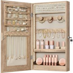 an open wooden jewelry cabinet filled with lots of necklaces