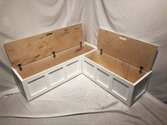 two wooden boxes sitting on top of a white sheet covered floor next to each other