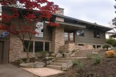 a large house with stone steps leading up to it's front door and trees in the background