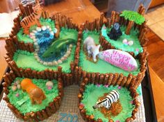 an animal themed birthday cake with animals on it's sides and trees in the middle