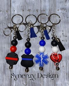 several key chains with medical symbols hanging from them on a wooden background that says synergy design