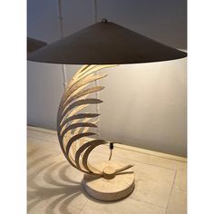 a lamp that is sitting on top of a table next to a light fixture with an umbrella shade over it