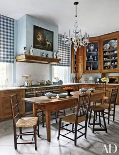 a kitchen with blue walls and wooden cabinets is pictured in this image, there are many chairs around the table