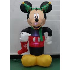 mickey mouse inflatable balloon with christmas stockings and stocking hanging from it's ear