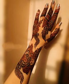 a woman's hand with hennap on it and some flowers painted on it