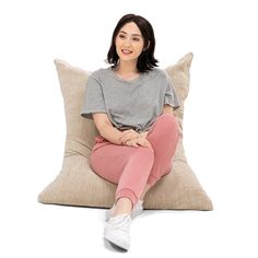 a woman sitting on a pillow with her legs crossed