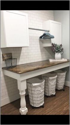 a kitchen counter with three trash cans under it