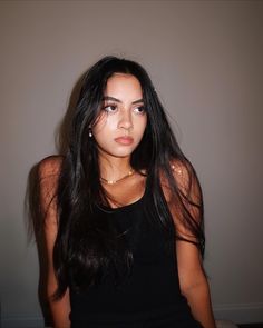 a young woman with long black hair posing for the camera