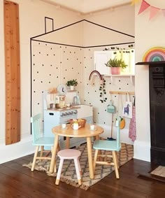 a child's play room with wooden furniture and decor on the walls, including a toy stove