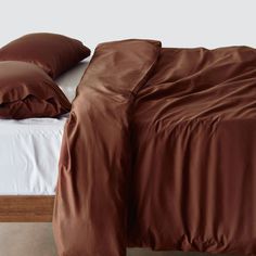 a bed with brown sheets and pillows on it