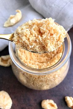 a spoon full of keto breadcrumbs on top of a glass jar