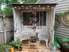 an old door is opened to reveal a garden shed with potted plants in it