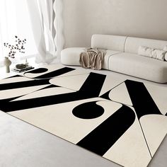 a living room with a white couch, black and white rugs and a large window