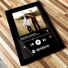 an mp3 player is sitting on the floor next to a wooden table with a black frame