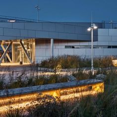 the building is lit up at night by street lights and grass in front of it