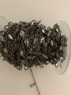 a bunch of beads that are sitting on a chain attached to a wall hanging from the ceiling