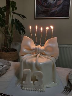 a birthday cake with candles in the shape of number twenty five and bow on top