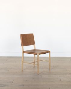 a wooden chair sitting on top of a hard wood floor next to a white wall