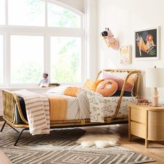 a child's bedroom with a bed, dresser and rugs in front of the window