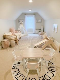 an attic bedroom with white furniture and rugs on the floor in front of a window