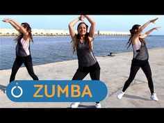 three women are doing yoga in front of the water with their hands up and arms out