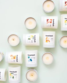 many different types of candles are arranged on the wall with one candle in between them