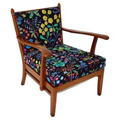 a wooden chair with floral upholstered fabric on it's armrests