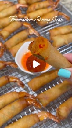 a person is holding up some food on a rack with sauce in the bowl next to them