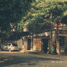 a white car parked in front of a building on the side of a road next to trees