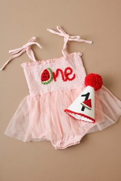 a pink and white birthday outfit with a one on it