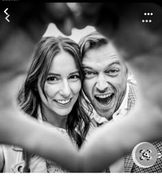 a man and woman are making heart shape with their hands