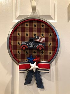 a patriotic door hanger with an american truck and stars on the front, red white and blue ribbon